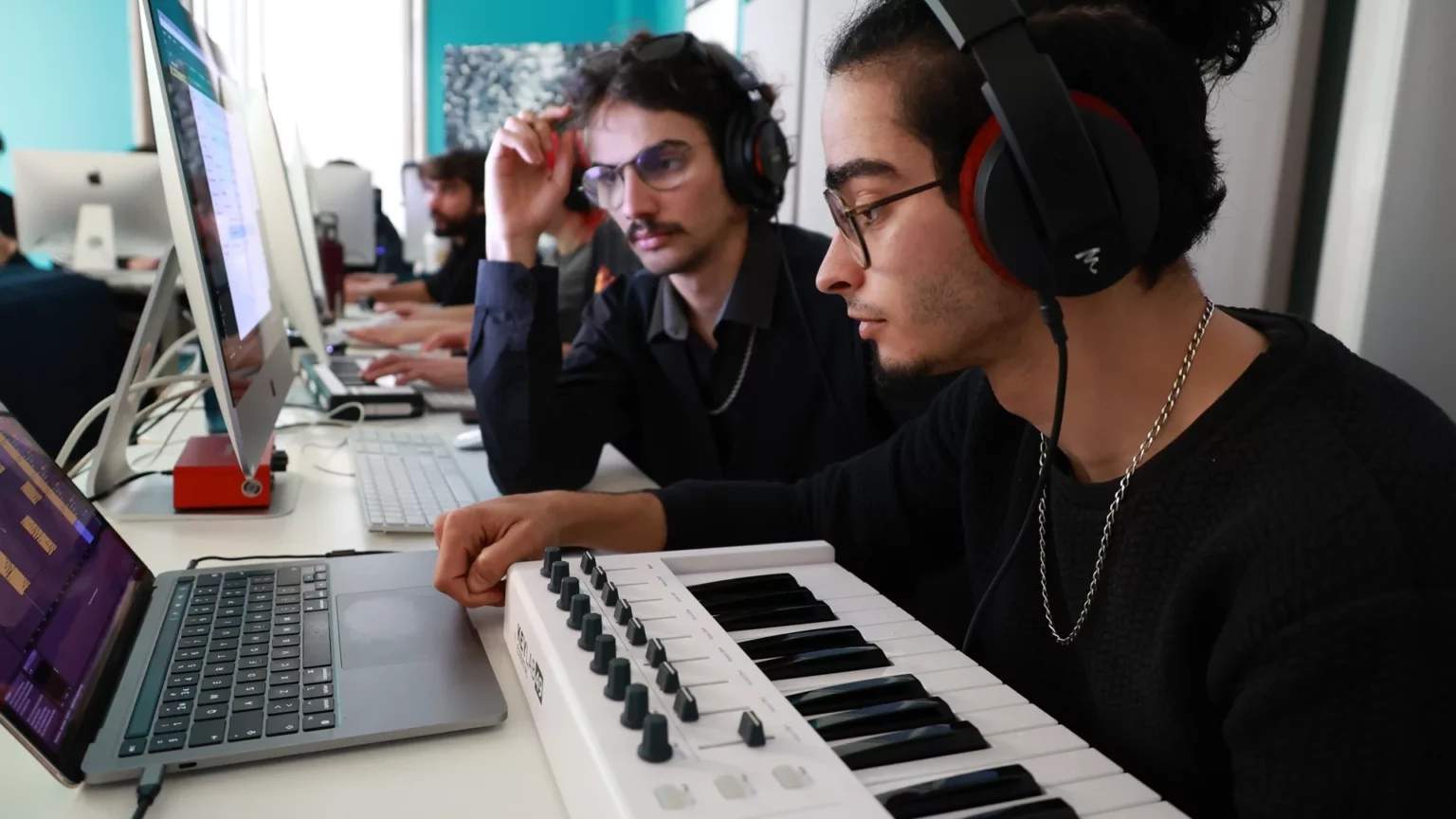 Aula prática do Curso de Criação Musical Produção e Técnicas de Som, com formandos a utilizar teclado MIDI e software de áudio.